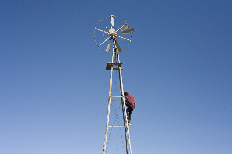 alex climbing windmill against blue sky